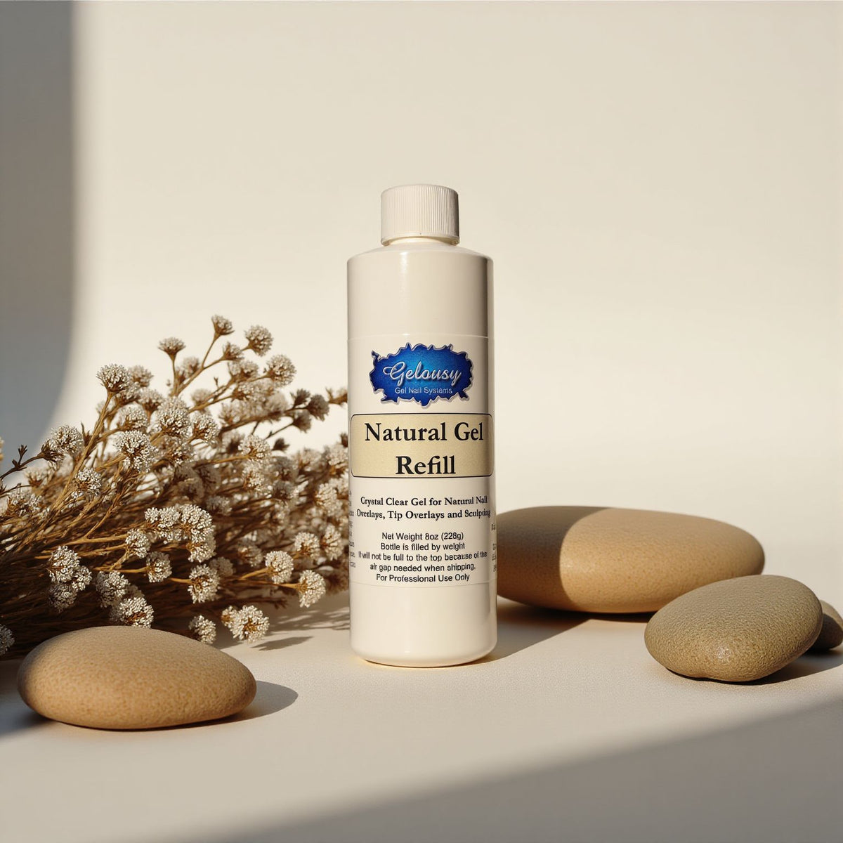 White plastic bottle of Natural Gel 8oz Refill with blue label, surrounded by beige stones and dried flowers on a light.