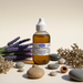 Amber bottle of Lavender Tea Tree Cuticle Oil 2oz surrounded by lavender, stones, and dried flowers in soft light